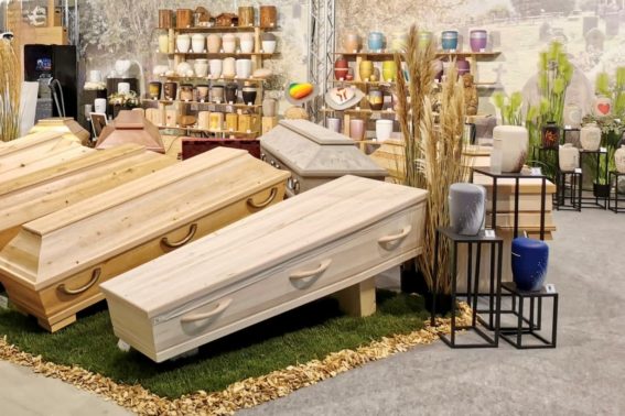 Eine Auswahl an Särgen und Urnen auf einem Messestand des Fachhandels für Bestattungsbedarf, Beck Pietätsbedarf